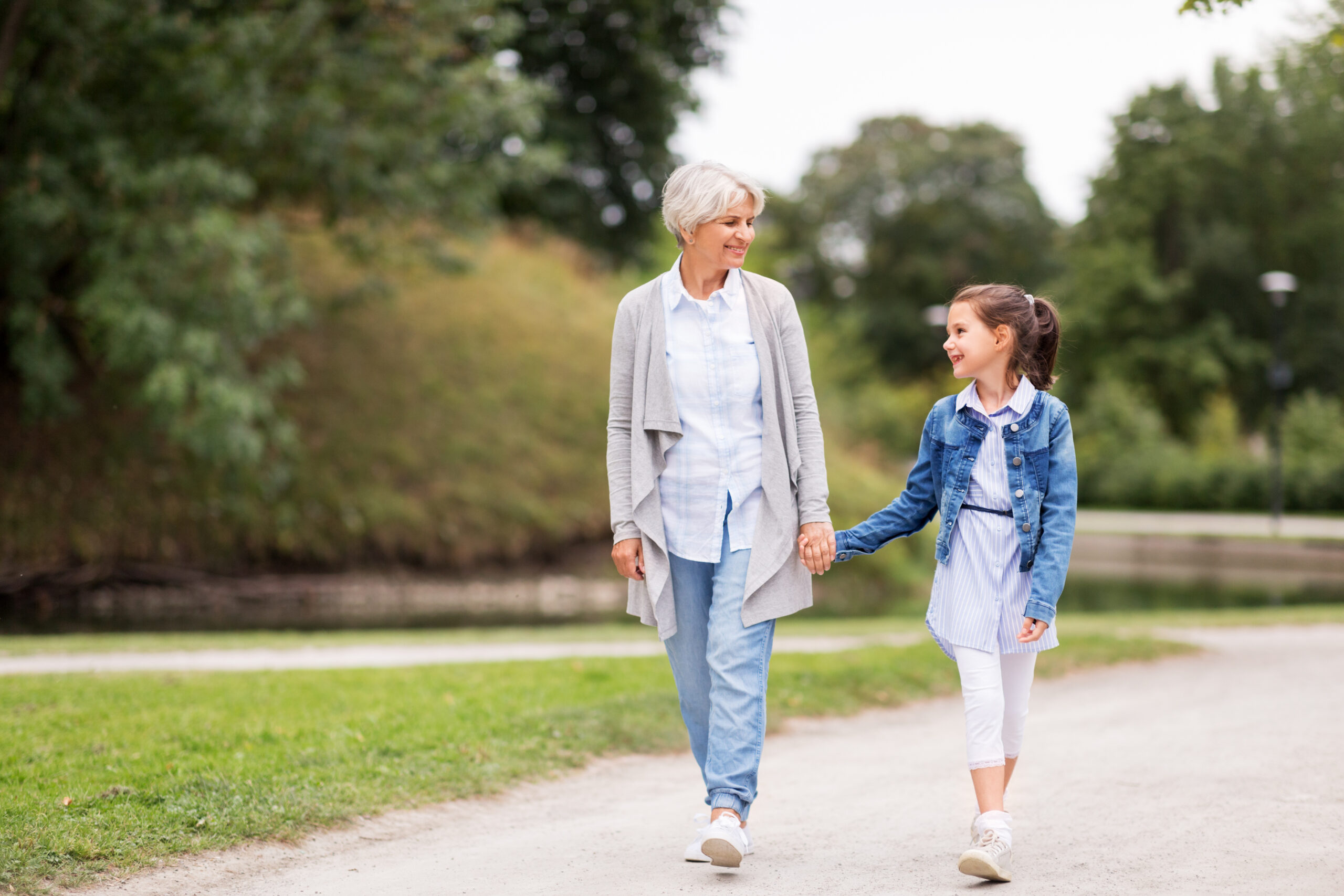 grandmother and granddaughter walking at park