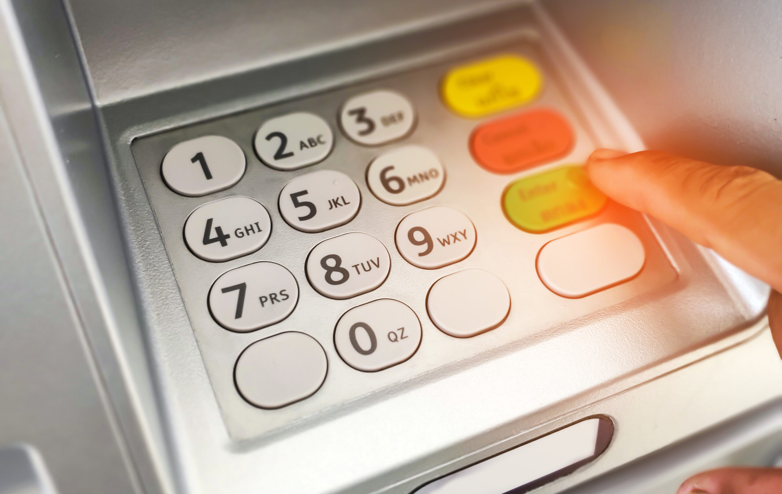 close up of hand entering on atm/bank machine keypad.