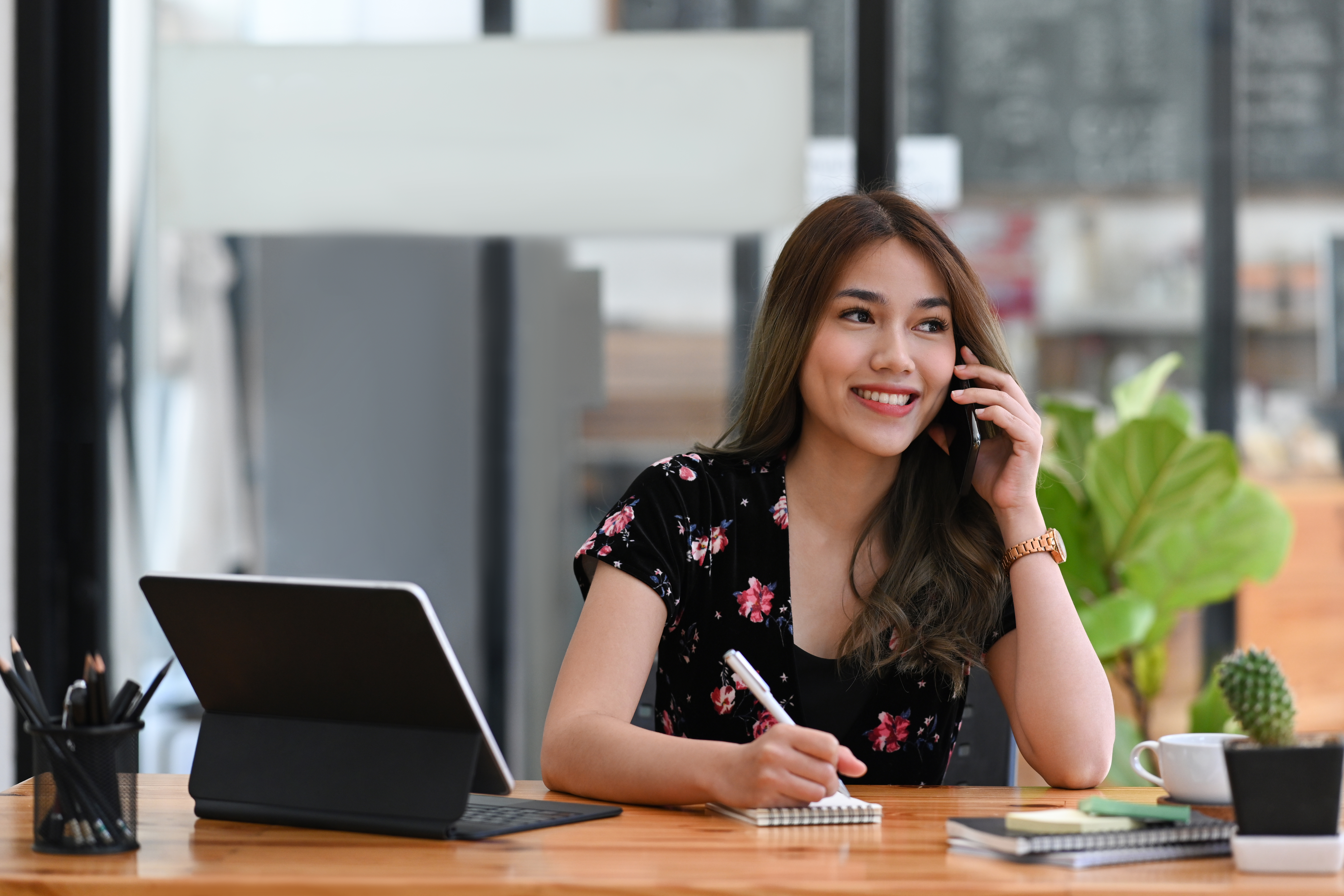 smiling young asian woman talking on mobile phone and making not