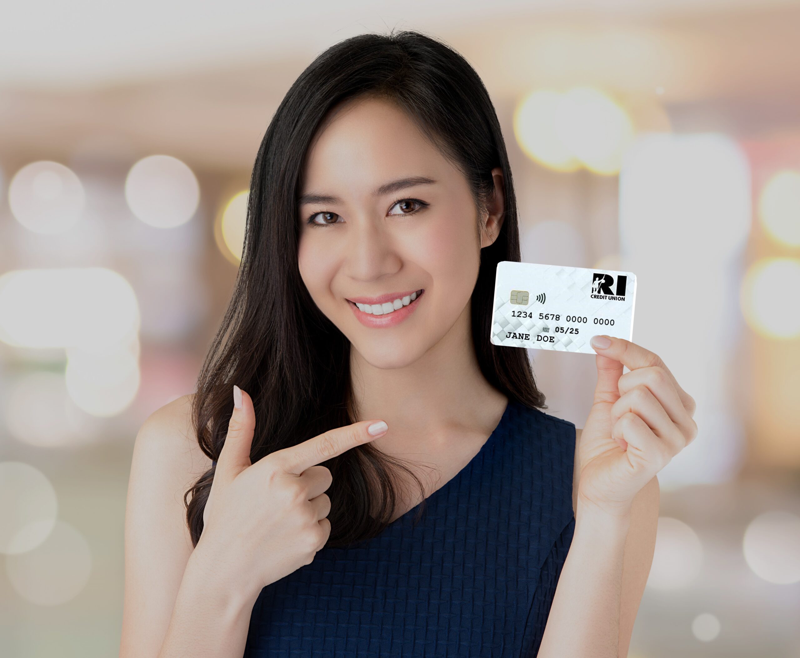 young smiling beautiful asian woman presenting credit card in hand